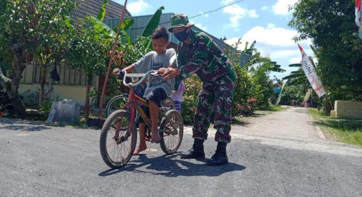  Jalan Aspal TMMD Bojonegoro Mulus, Satgas Ajari Anak Ngrancang Bersepeda